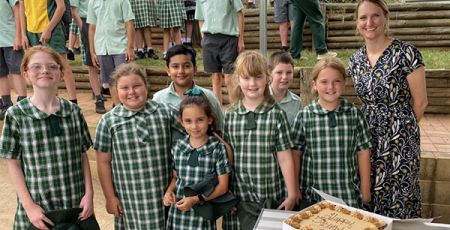 Principal and students celebrating with cake