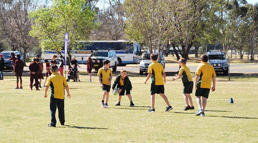 Students actively participating in a football game, displaying teamwork and sportsmanship.